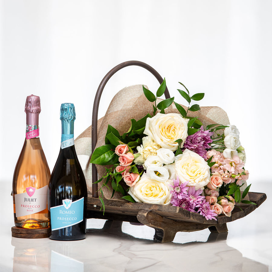 Prosecco and Petals gift with two bottles of sparkling wine and a bouquet of cream and pink roses