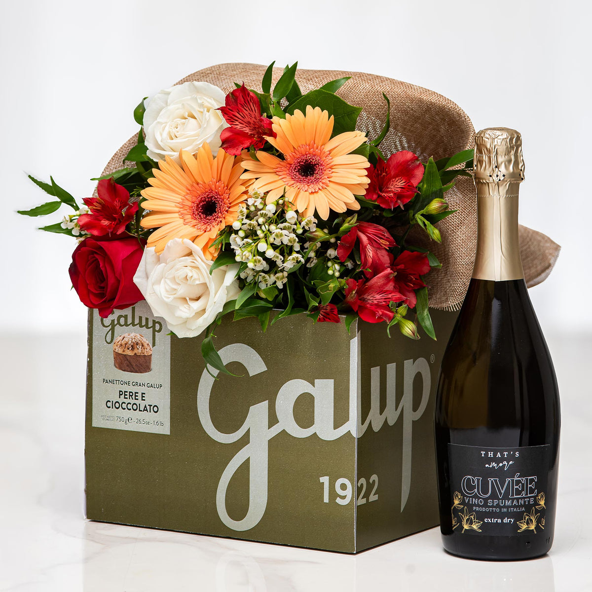 Tempting Trio gift with a Galup chocolate box, sparkling wine and an arrangement of gerberas and roses