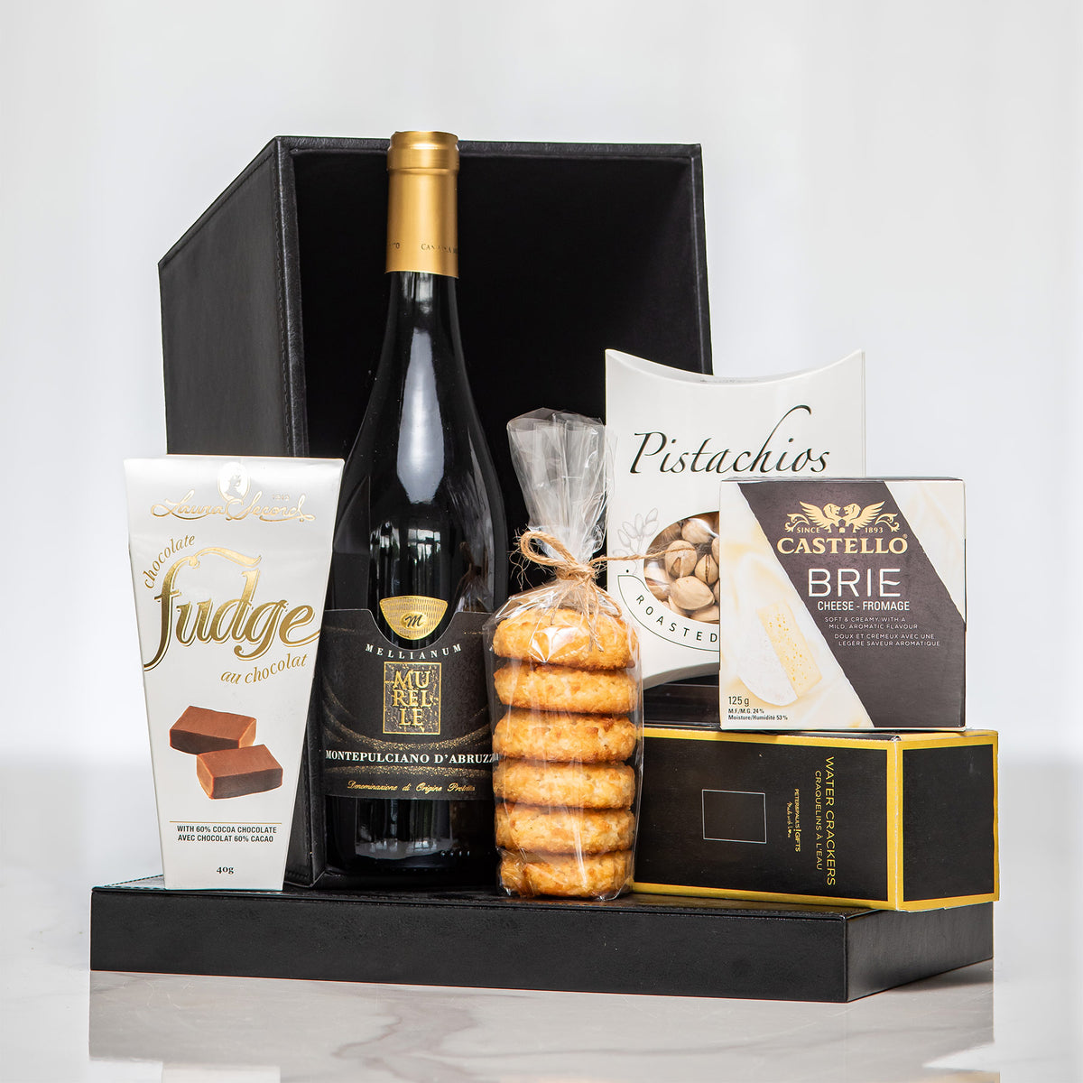 Uptown black gift box with a bottle of wine, pistachios, brie, crackers and fudge