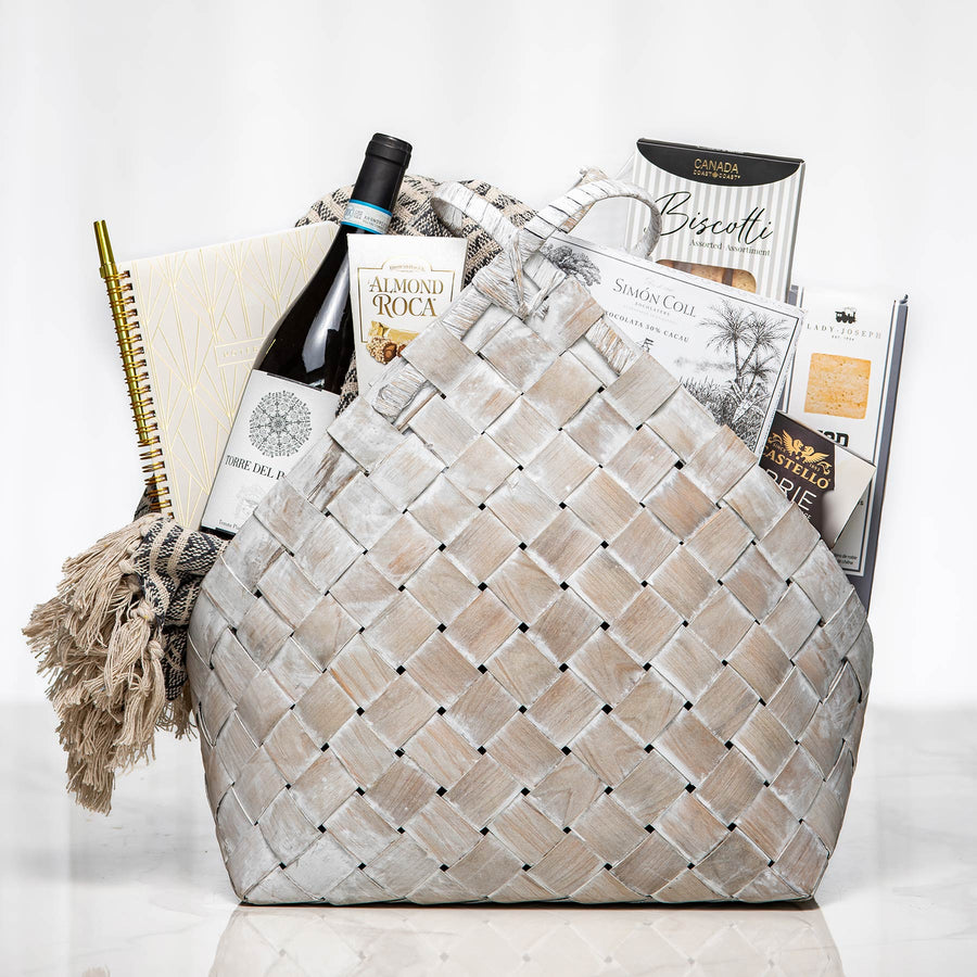 Woven Wonders grey woven basket with a notebook, a bottle of wine, brie and gourmet snacks